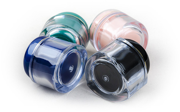 tri bočice za kozmetiku u raznim bojama sa poklopcem